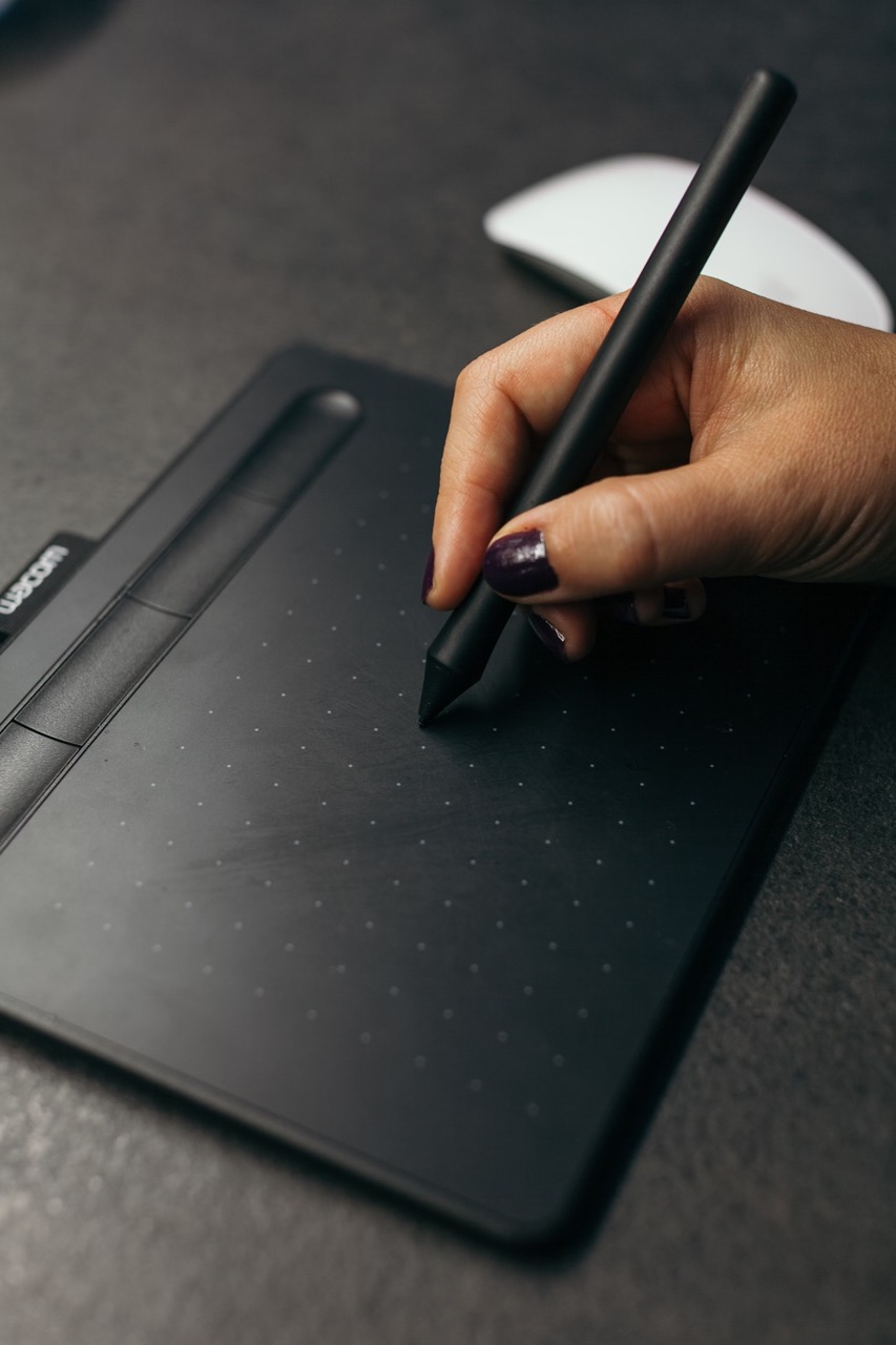 A graphic design tablet with someone drawing on it.