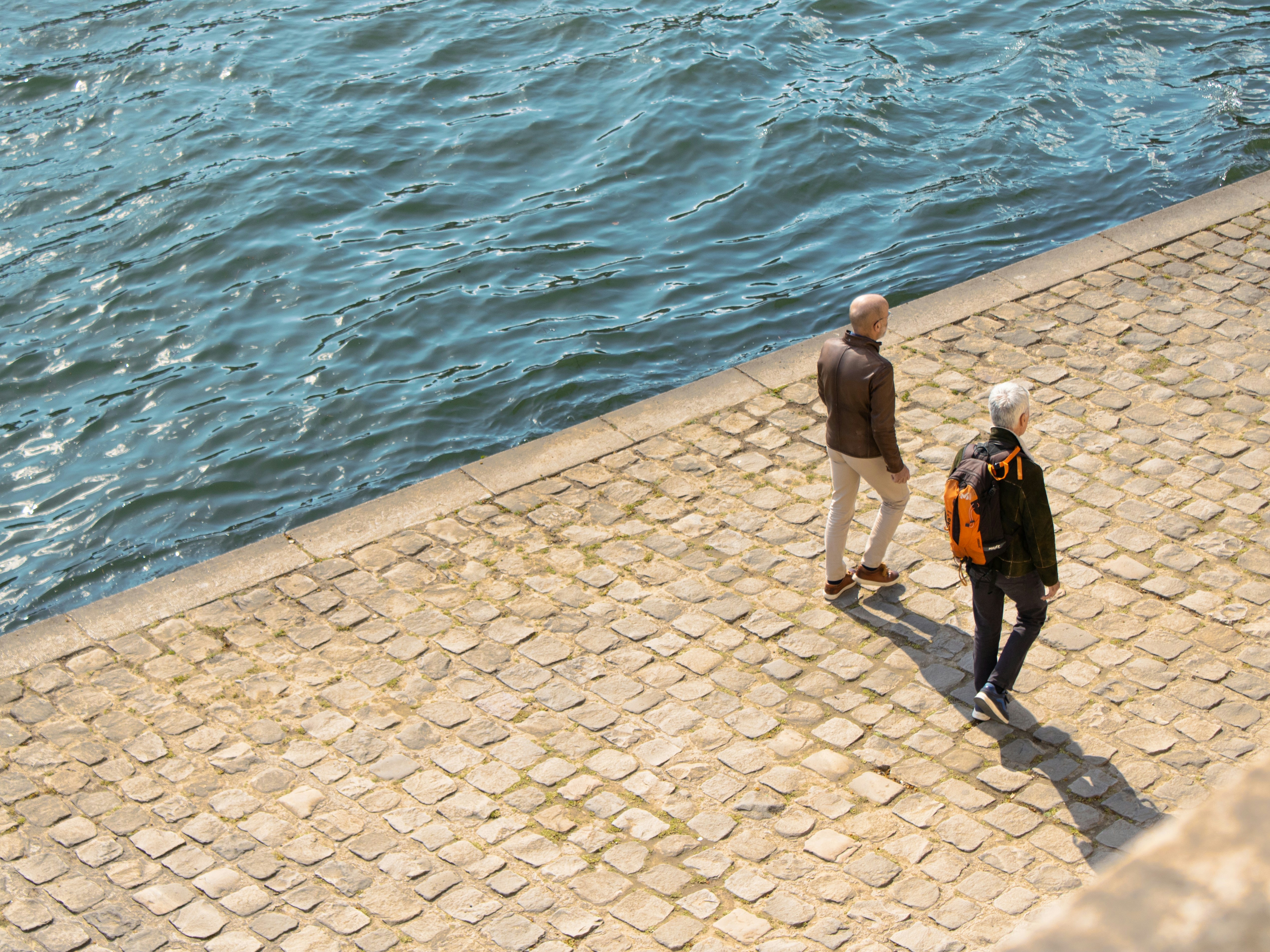 Photo of two people walking by the river